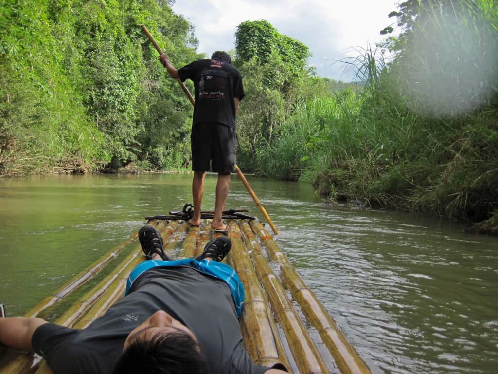 chiang mai bamboo rafting with man lying down and pilot manning raft