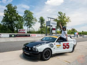 posing with mustang race car at calabogie motorsports park