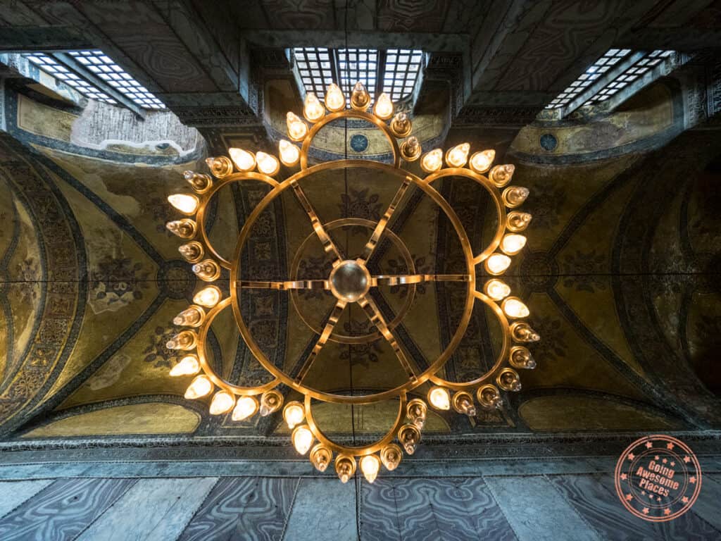 looking up at the golden chandelier and ceiling of hagia sophia in istanbul