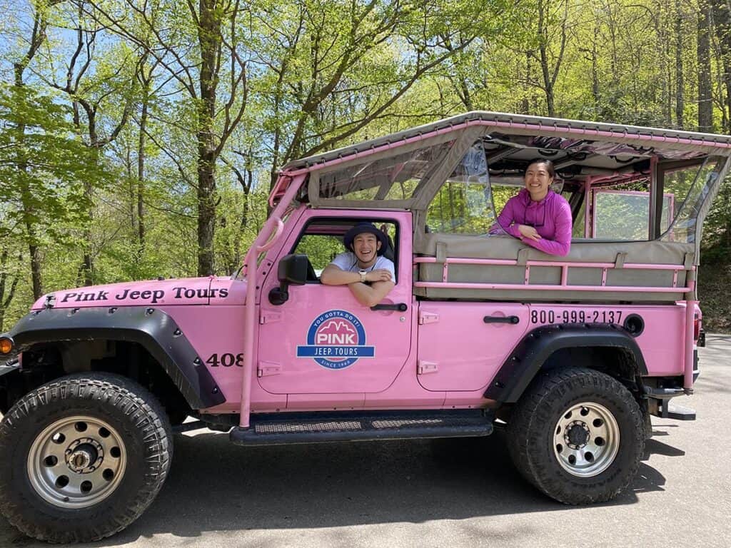 pink jeep tours in great smoky mountains with couple posing with the vehicle