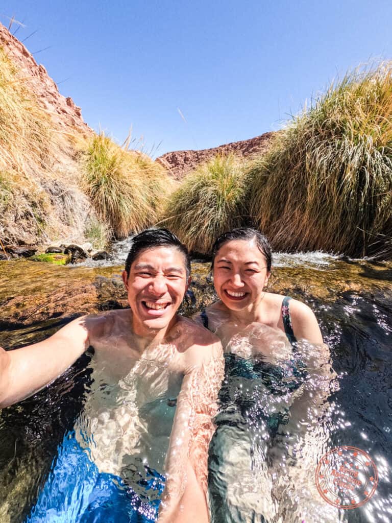 asian couple enjoying hot springs at termas de puritama